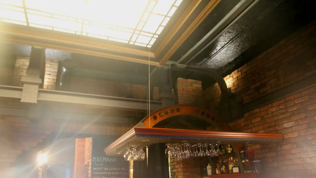 The bar, with brick walls, a skylight and glasses hanging over the counter