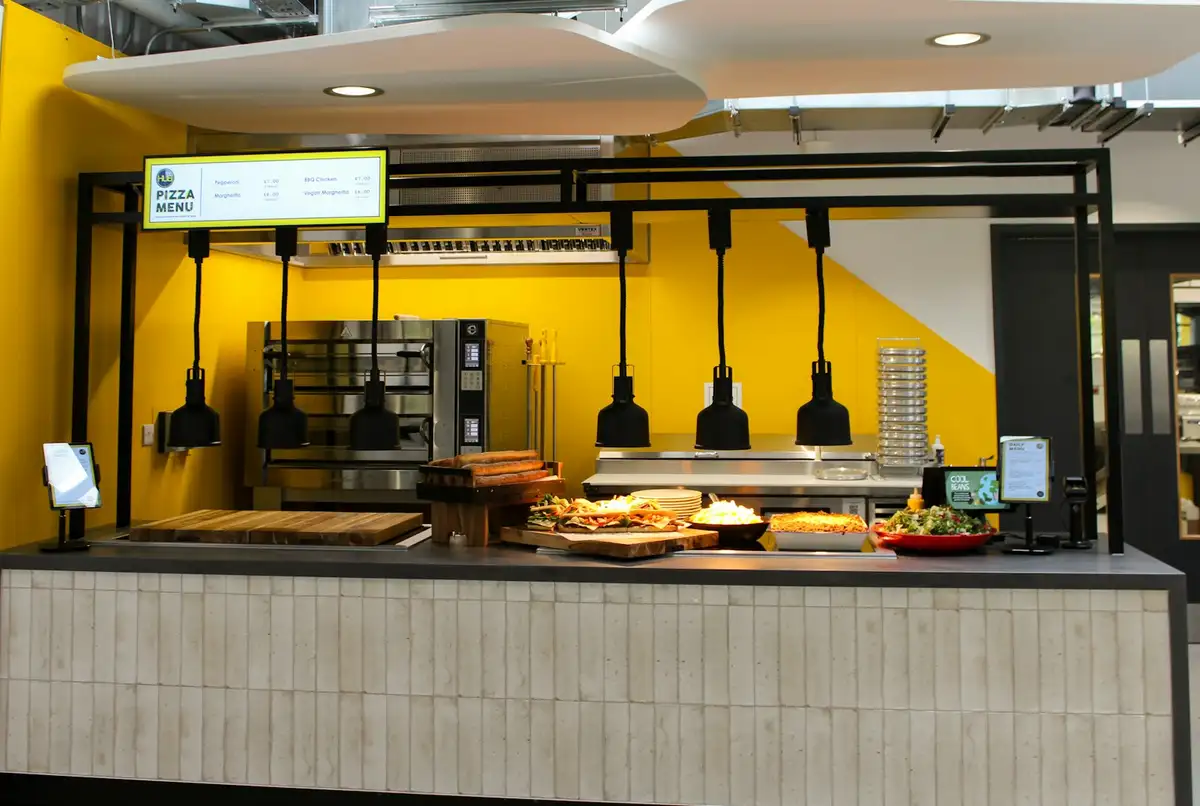 The counter, with pendant lamps over the pass and a yellow back wall