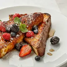 Thick-cut French toast with strawberries, blueberries, raspberries and blackberries, dusted with sugar