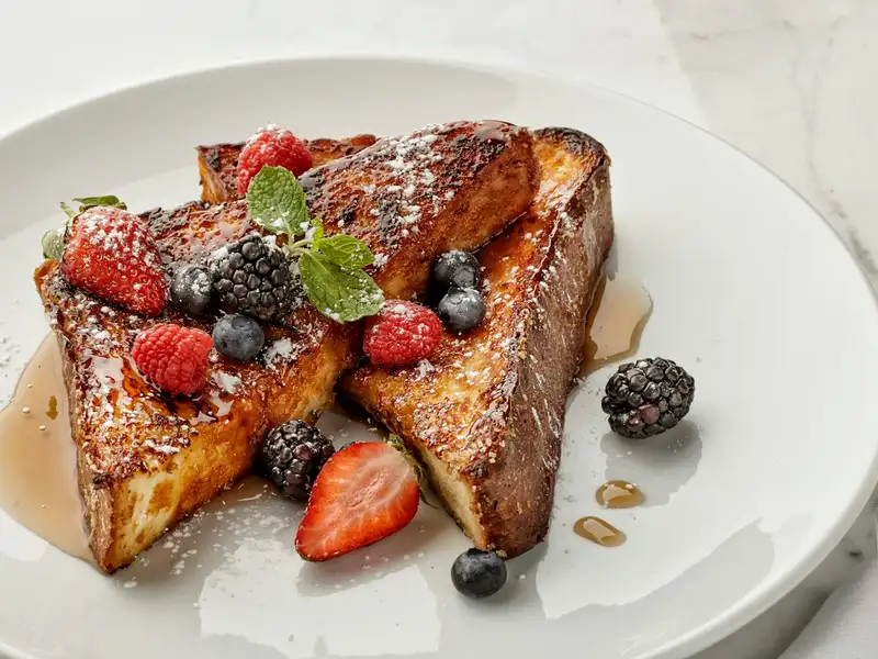 Thick-cut French toast with strawberries, blueberries, raspberries and blackberries, dusted with sugar