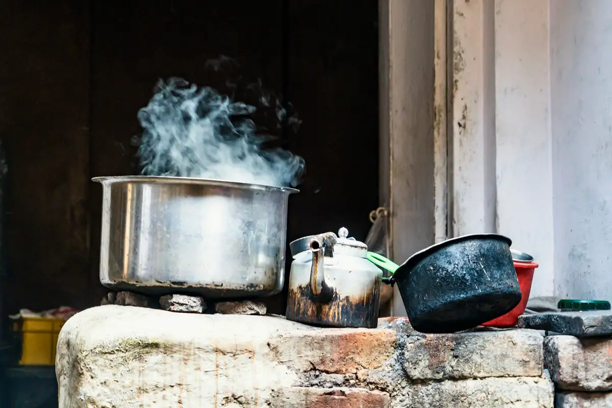 Steam rising from a big steel stock pot on a stove