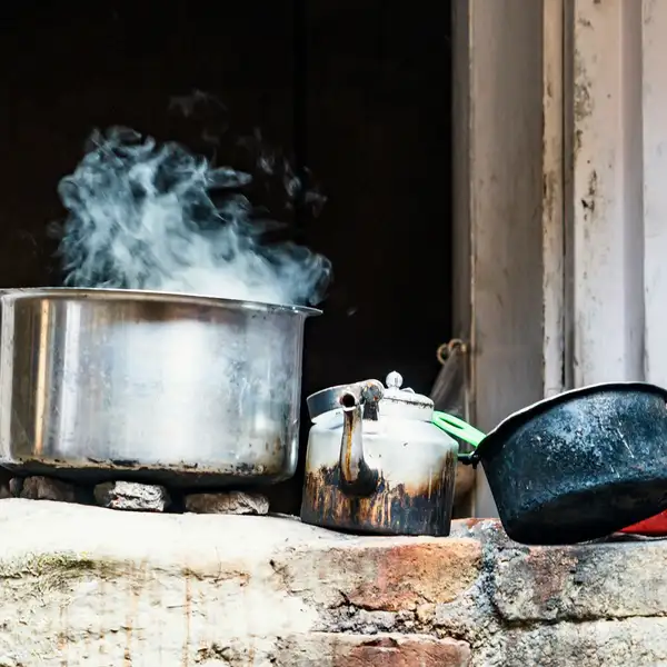 Steam rising from a big steel stock pot on a stove